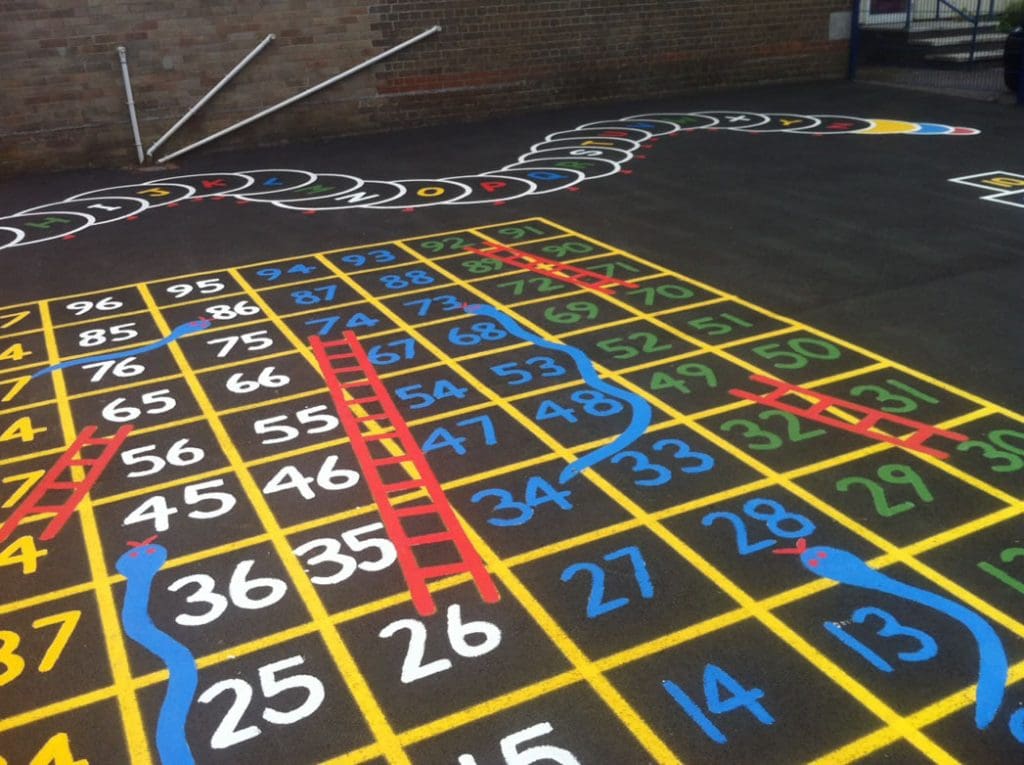 Colorful playground markings featuring a snakes and ladders game, designed to encourage interactive and educational outdoor play for children.