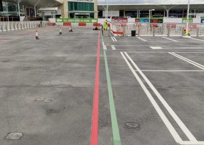Freshly painted car park lining with red and green lines marking bays and pedestrian walkways at a shopping centre, completed by Bournemouth White Lining for professional car park lining services