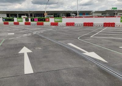Freshly painted car park lining with white directional arrows and parking bays at a retail park, completed by Bournemouth White Lining for professional car park lining services