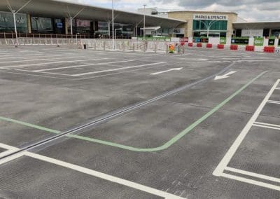 Freshly painted white lines and directional arrows in a shopping centre car park, completed by Bournemouth White Lining for professional car park lining services