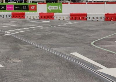 Freshly painted white lines and directional markings in a retail shopping centre car park, completed by Bournemouth White Lining for professional car park lining services