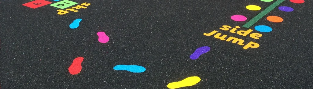 Bright and colorful playground markings, including footprints, hopscotch, and activity labels, designed to promote fun and interactive play for children.