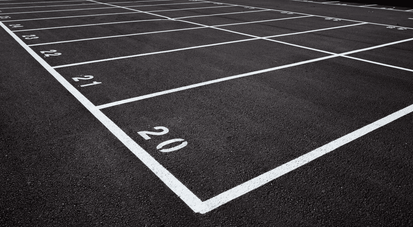 Freshly painted white lines and numbered bays in an outdoor car park, completed by Bournemouth White Lining for professional car park lining services