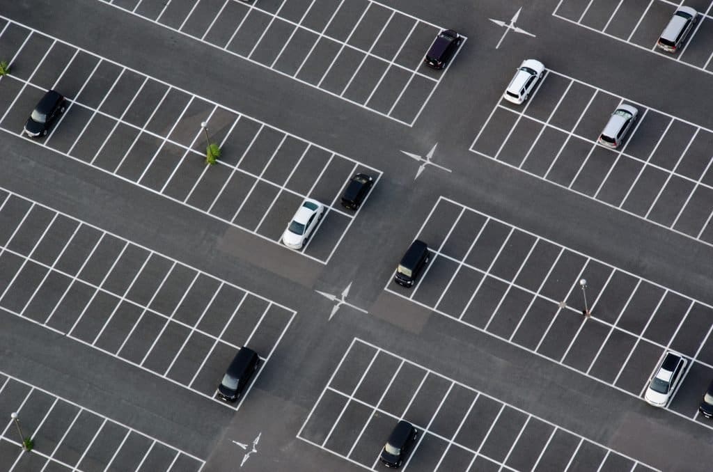 An aerial view of a spacious parking lot in Bournemouth with freshly painted white parking lines, evenly dividing the spaces for clear vehicle organization.