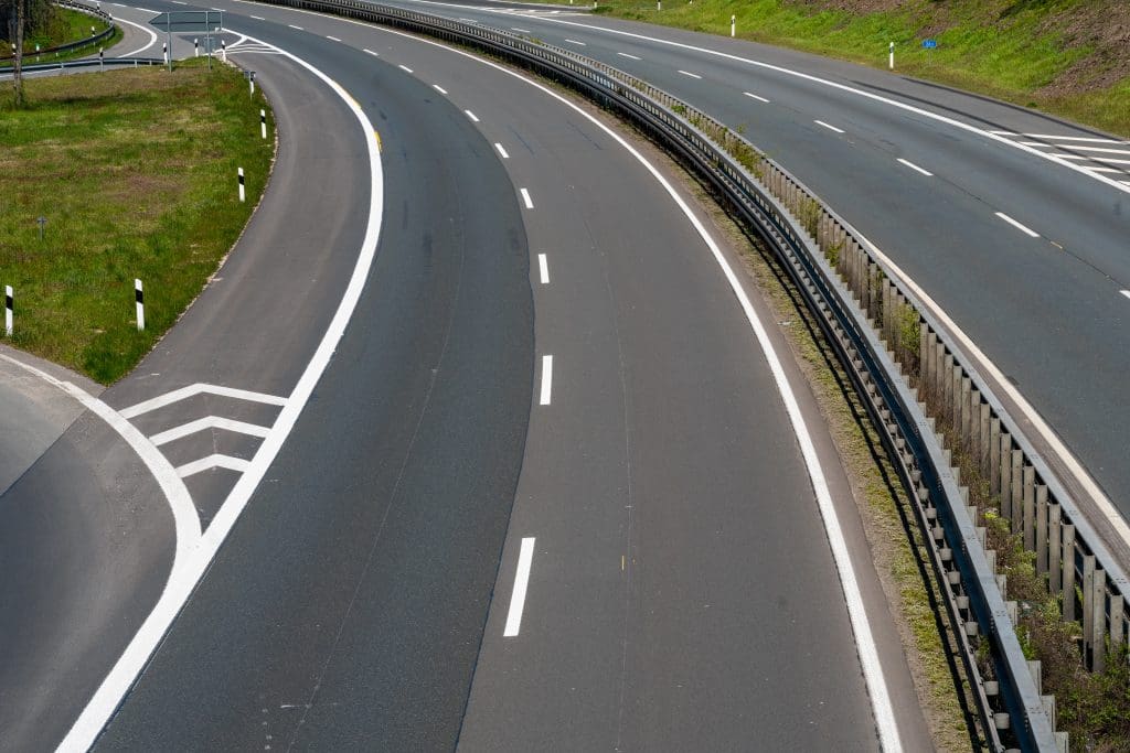 Wide highway with clear white road markings, including lane dividers and shoulder lines, ensuring safe and efficient traffic flow.